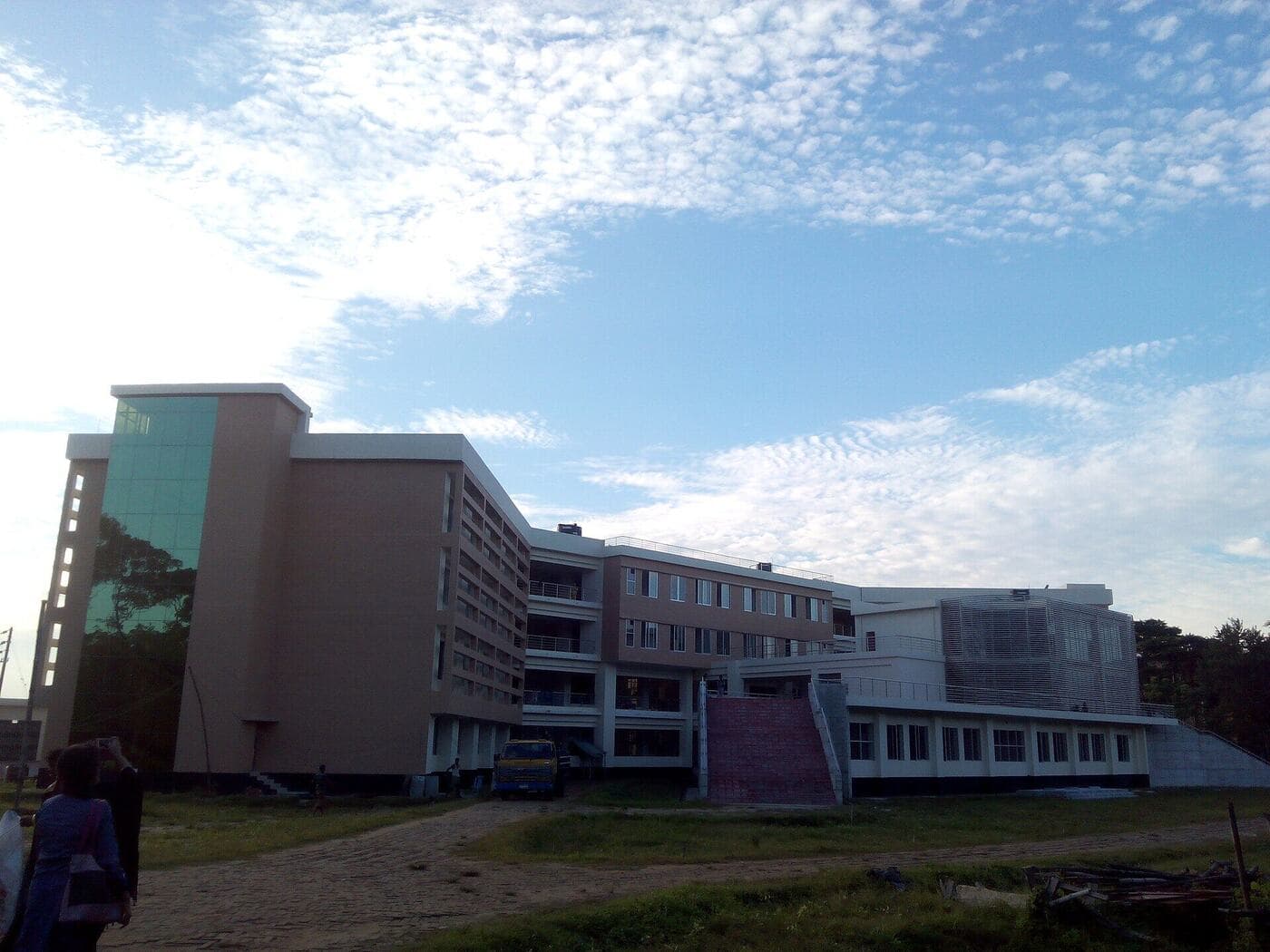 The IT building of SUST beneath a blue sky with scattered clouds
