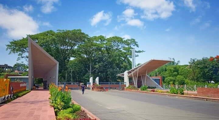 The main gate of SUST with its two angled canopies under a blue sky